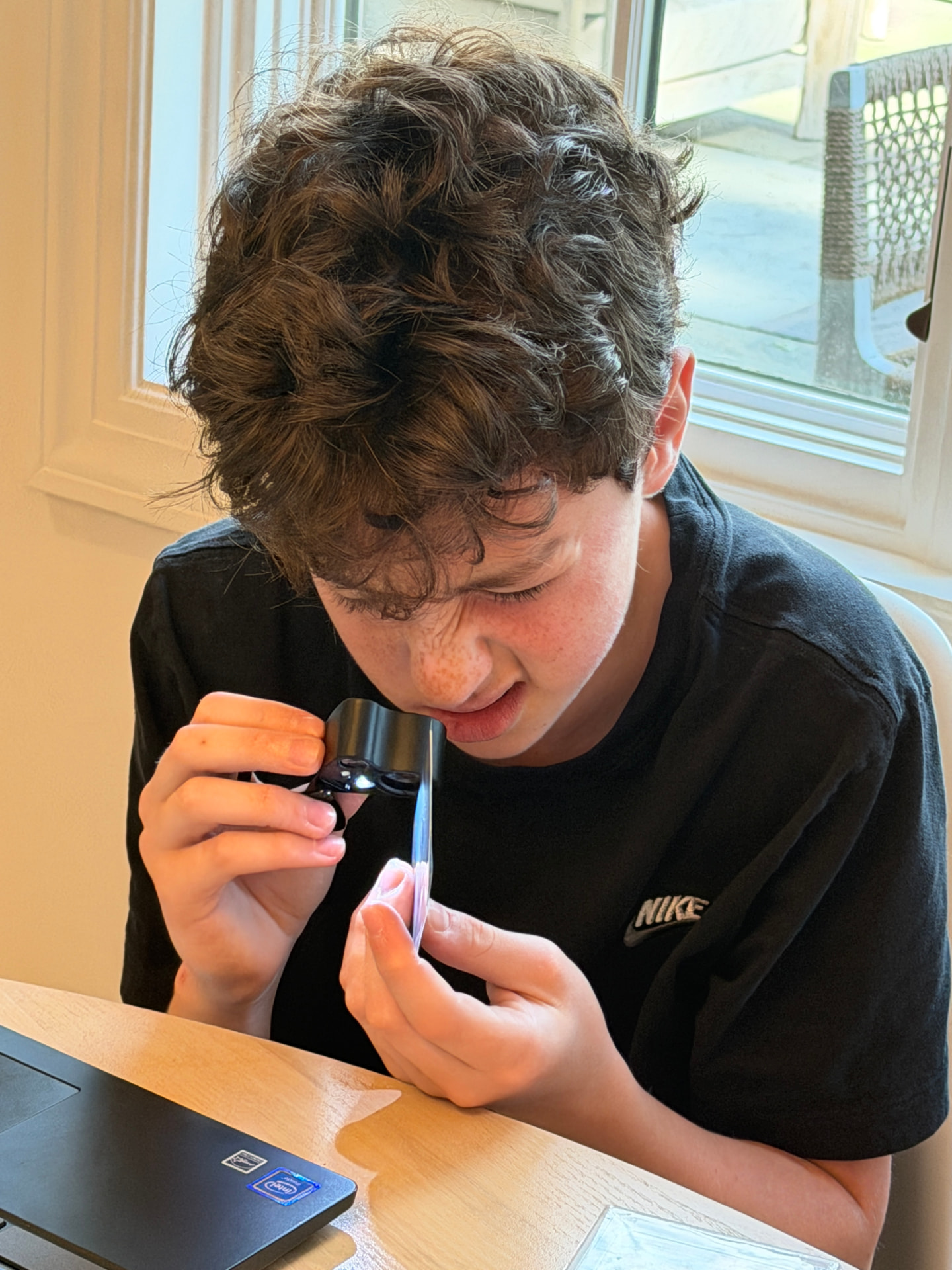 Henry examining a Pokémon card with a jeweler's loupe
